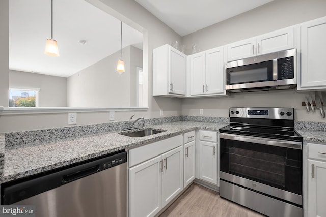 kitchen featuring sink, white cabinetry, light hardwood / wood-style floors, stainless steel appliances, and light stone counters