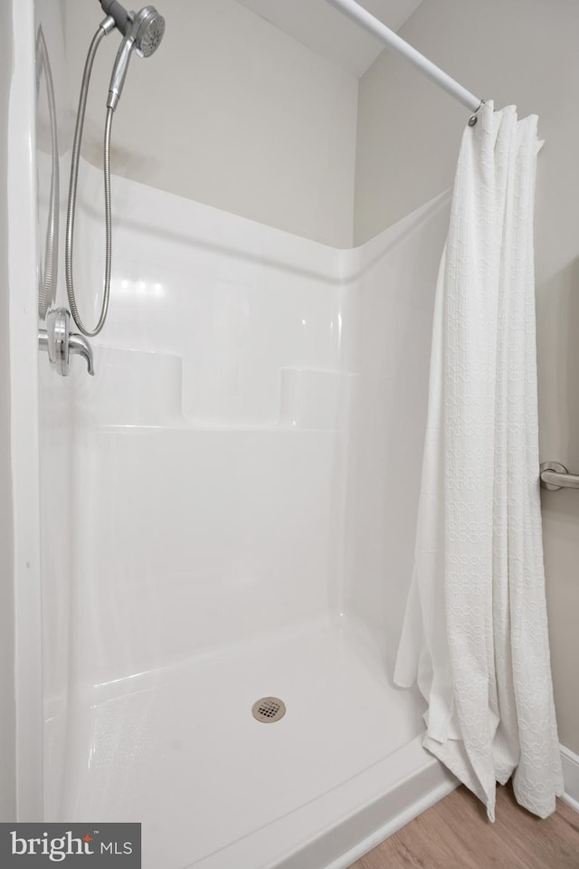 bathroom with hardwood / wood-style floors and a shower with curtain