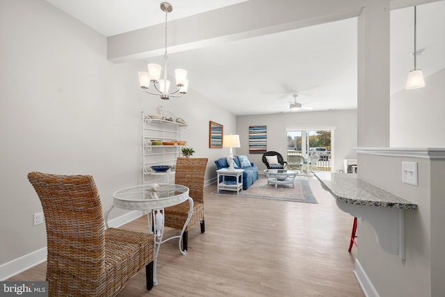 dining area featuring wood-type flooring and ceiling fan with notable chandelier