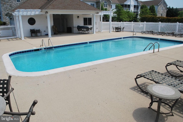 view of swimming pool with a patio and a pergola