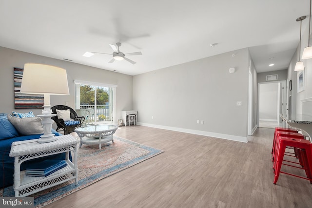 living room featuring wood-type flooring and ceiling fan