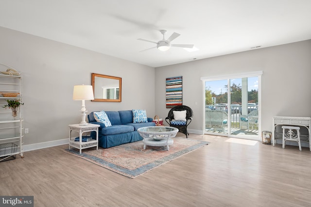 living room with ceiling fan and light hardwood / wood-style flooring