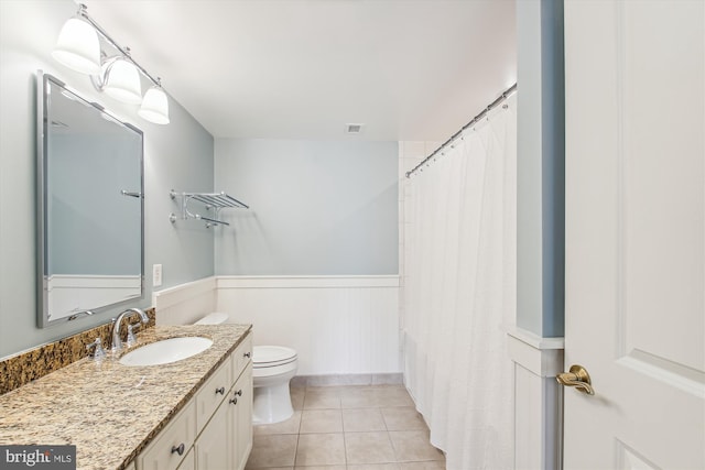 full bathroom with shower / bath combo with shower curtain, tile patterned floors, vanity, and toilet