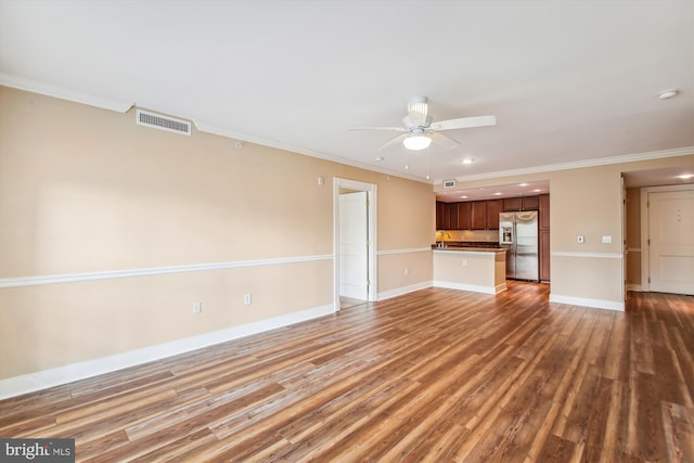 unfurnished living room with ornamental molding, ceiling fan, dark wood-type flooring, and sink