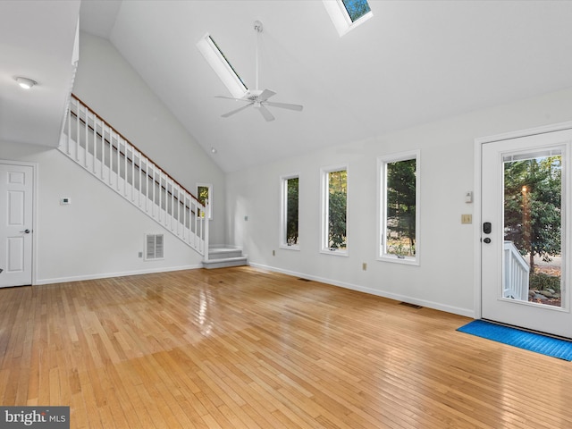 unfurnished living room featuring ceiling fan, high vaulted ceiling, plenty of natural light, and light wood-type flooring