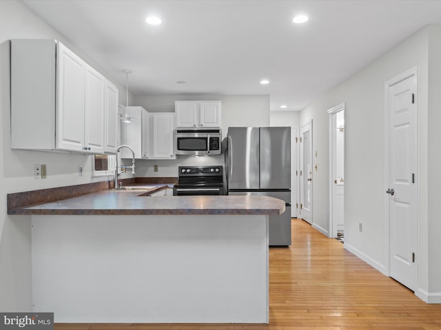 kitchen with white cabinetry, appliances with stainless steel finishes, sink, and kitchen peninsula