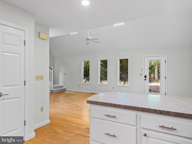 kitchen featuring white cabinetry, lofted ceiling, light hardwood / wood-style flooring, and plenty of natural light