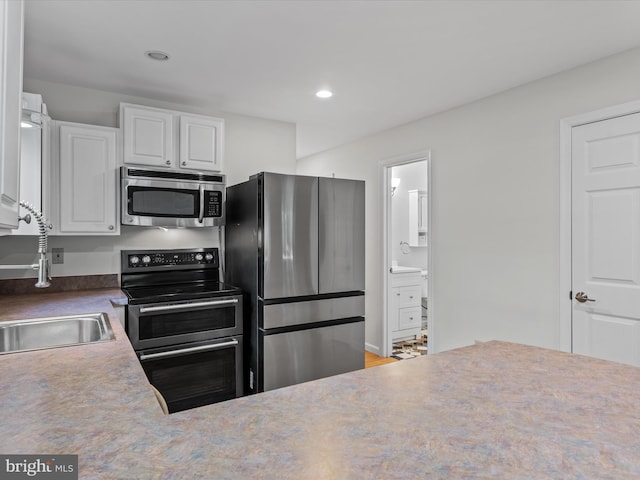 kitchen featuring appliances with stainless steel finishes, white cabinetry, and sink