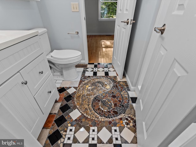 bathroom featuring toilet, vanity, and wood-type flooring