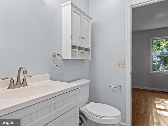 bathroom featuring toilet, hardwood / wood-style floors, and vanity