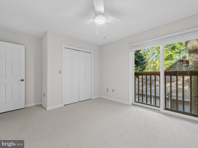 unfurnished bedroom featuring light carpet, a closet, access to exterior, and ceiling fan