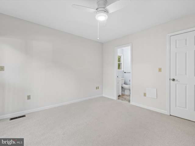 unfurnished bedroom with ensuite bath, light carpet, and ceiling fan