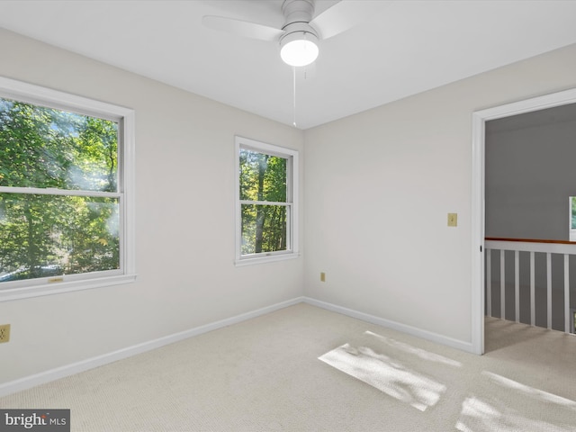 carpeted spare room featuring ceiling fan