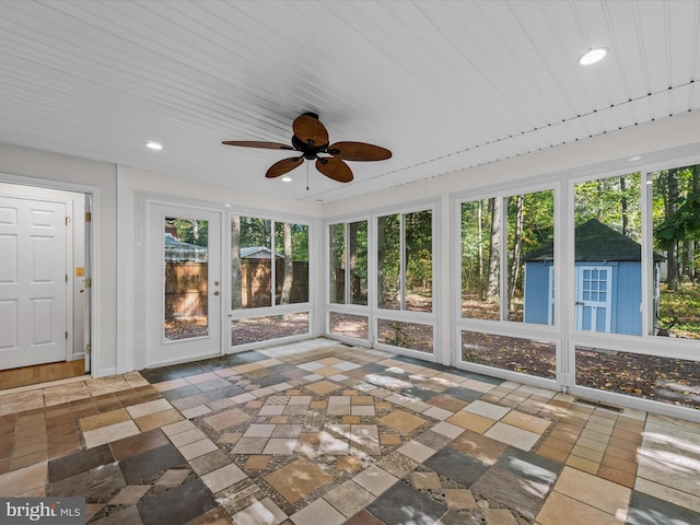 unfurnished sunroom with ceiling fan