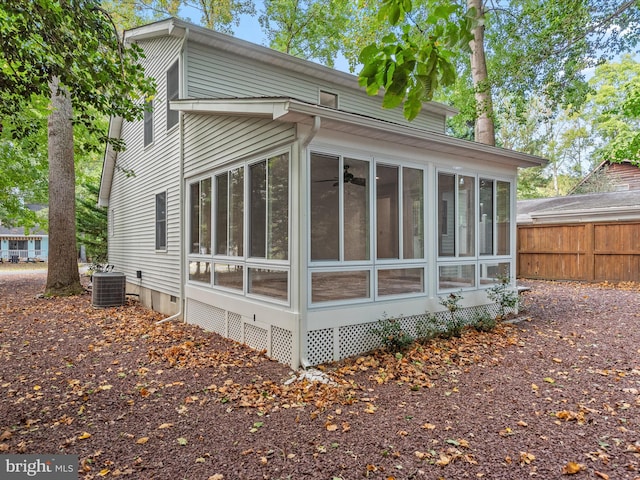 view of property exterior featuring central air condition unit and a sunroom