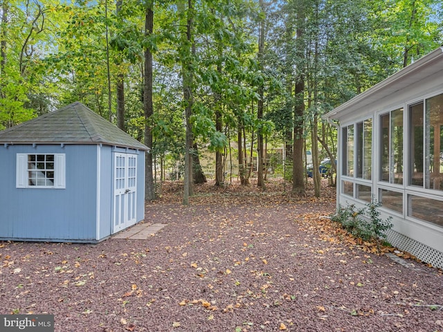 view of yard featuring a sunroom and a shed