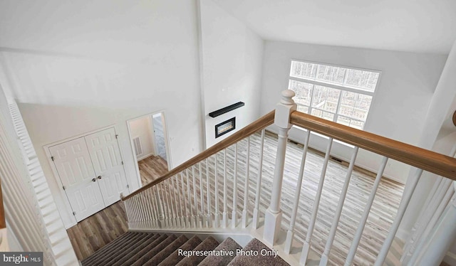 stairway featuring vaulted ceiling and hardwood / wood-style floors