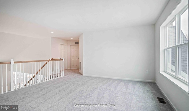 carpeted spare room featuring a wealth of natural light