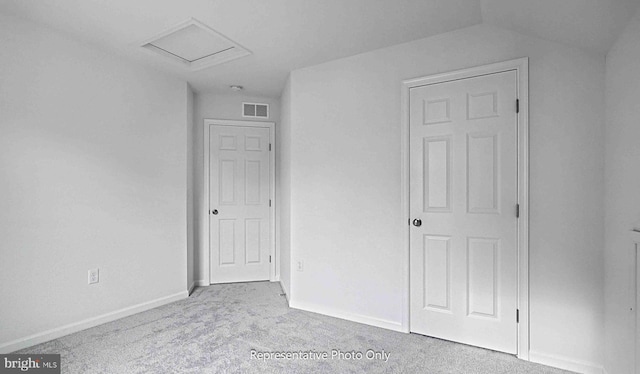 unfurnished bedroom with lofted ceiling and light colored carpet