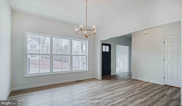 interior space with a notable chandelier and hardwood / wood-style flooring