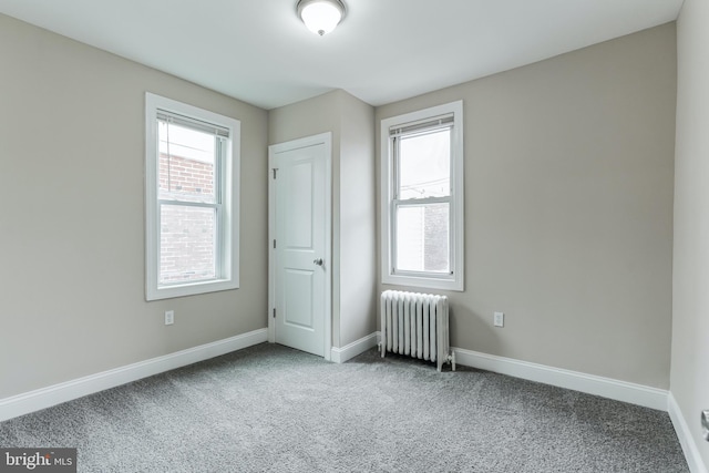 unfurnished room with carpet flooring and radiator heating unit