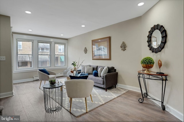 living room with light wood-type flooring and baseboard heating