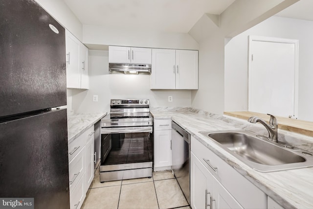 kitchen with sink, light stone countertops, white cabinetry, light tile patterned floors, and appliances with stainless steel finishes