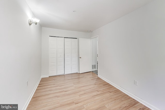 unfurnished bedroom with light hardwood / wood-style flooring and a closet