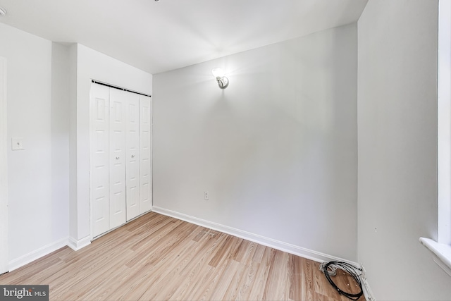 unfurnished bedroom with a closet and light wood-type flooring