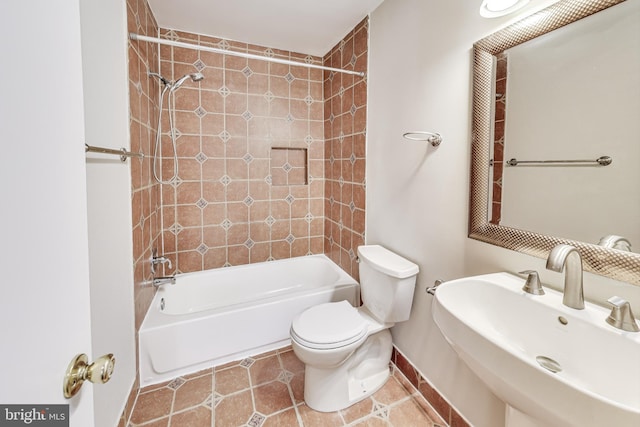 full bathroom featuring sink, tiled shower / bath combo, toilet, and tile patterned flooring