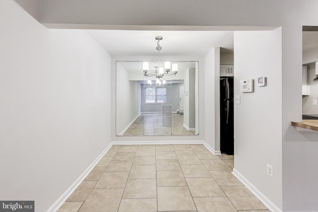 hall featuring a notable chandelier and light tile patterned floors