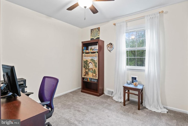 carpeted home office featuring ceiling fan