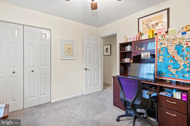 carpeted home office featuring ceiling fan