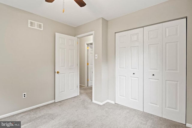 unfurnished bedroom featuring light carpet, a closet, and ceiling fan