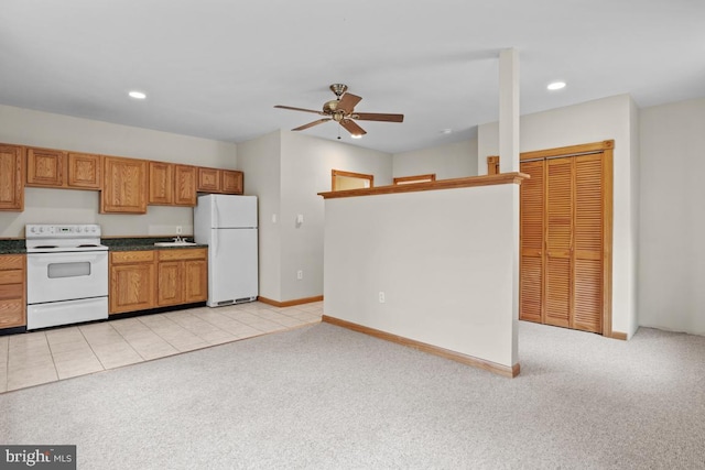 kitchen featuring white appliances, ceiling fan, light carpet, and sink