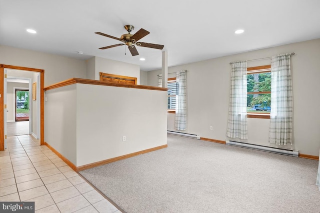 spare room with a baseboard heating unit, ceiling fan, and light colored carpet