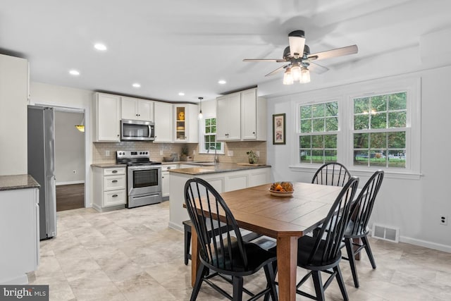 dining room featuring ceiling fan and sink