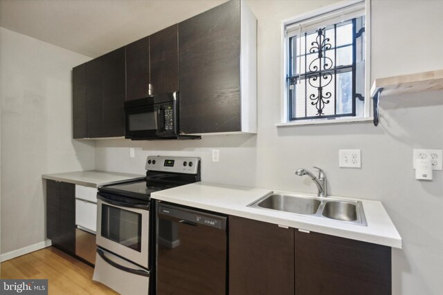 kitchen with sink, black appliances, dark brown cabinets, and light hardwood / wood-style floors