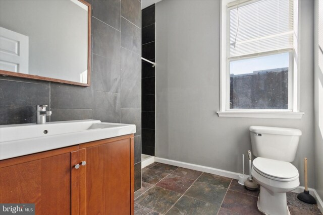 bathroom featuring vanity, a shower, and toilet