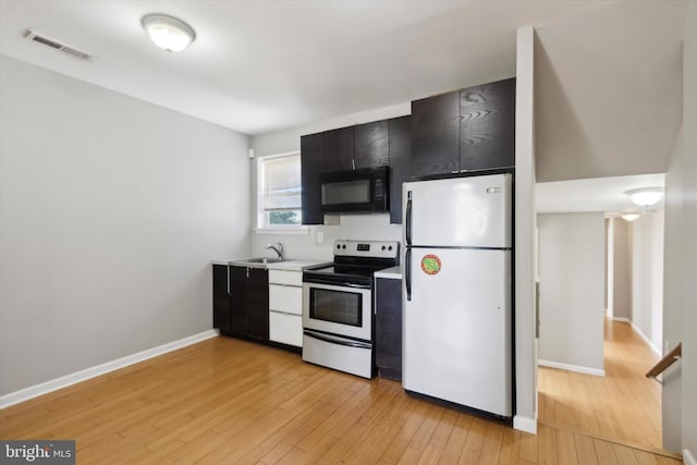 kitchen featuring white fridge, electric stove, sink, and light hardwood / wood-style floors