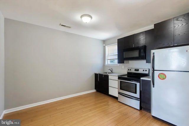 1716 N 18th St, Philadelphia, PA 19121 - kitchen featuring stainless steel electric range, dark cabinetry, black microwave, visible vents, and freestanding refrigerator