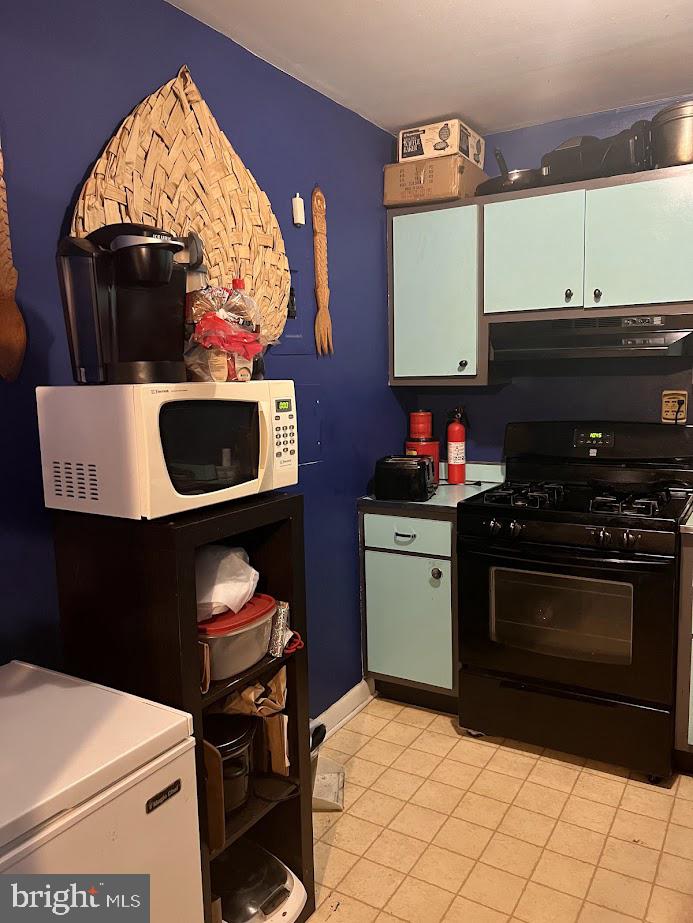 kitchen with gas stove, light tile patterned flooring, and ventilation hood