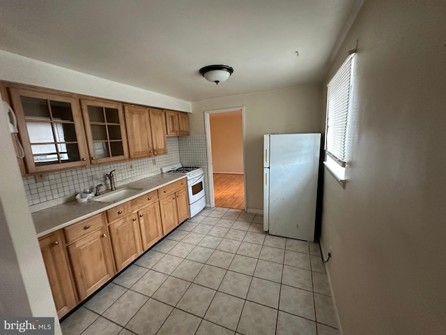 kitchen featuring plenty of natural light, sink, white appliances, and tasteful backsplash