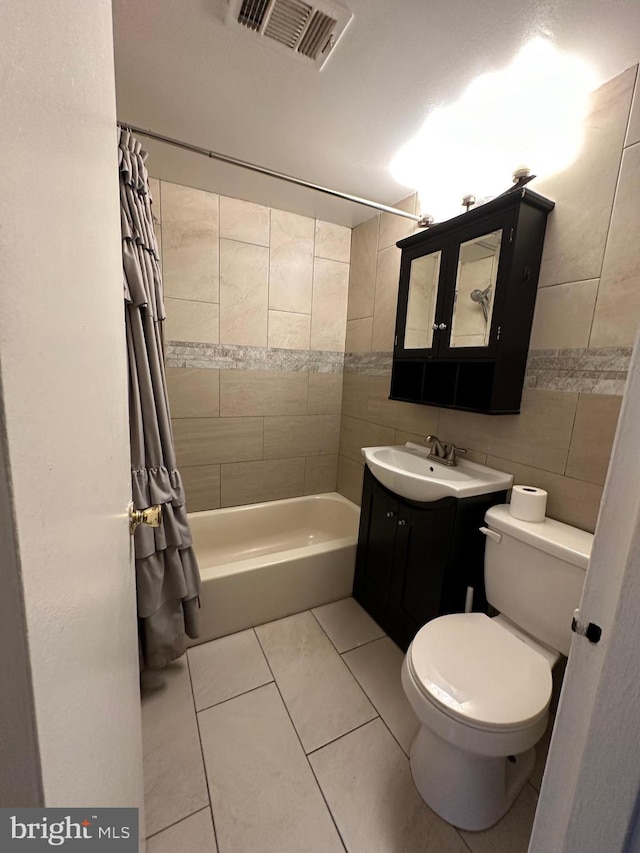 full bathroom featuring tile walls, tile patterned flooring, shower / bathtub combination with curtain, vanity, and toilet