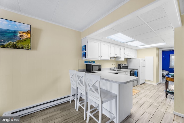 kitchen featuring light wood-type flooring, white cabinetry, kitchen peninsula, electric stove, and baseboard heating