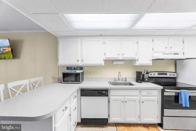 kitchen featuring white cabinets, sink, kitchen peninsula, appliances with stainless steel finishes, and light wood-type flooring