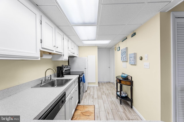 kitchen with white cabinets, sink, light hardwood / wood-style flooring, a paneled ceiling, and appliances with stainless steel finishes