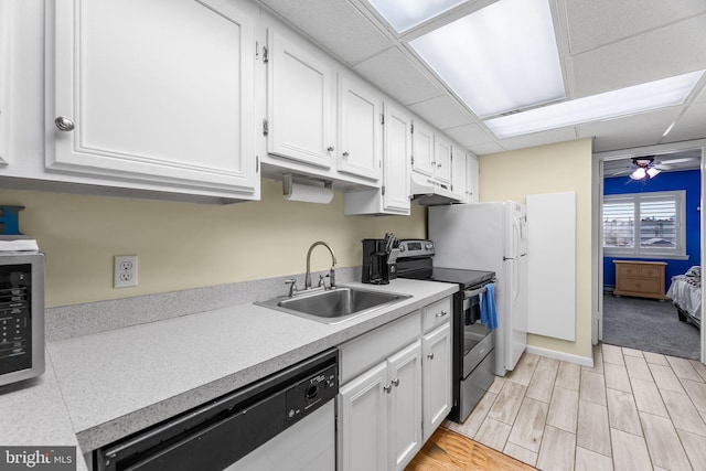 kitchen featuring white cabinets, sink, a paneled ceiling, appliances with stainless steel finishes, and light wood-type flooring