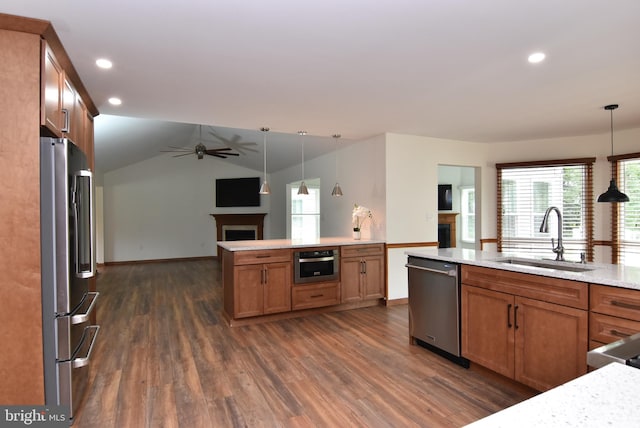 kitchen with hanging light fixtures, stainless steel appliances, sink, vaulted ceiling, and dark hardwood / wood-style flooring