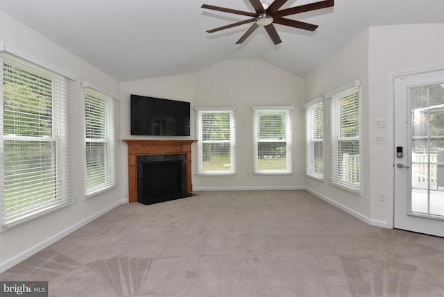 unfurnished living room with light carpet, lofted ceiling, a high end fireplace, and a healthy amount of sunlight